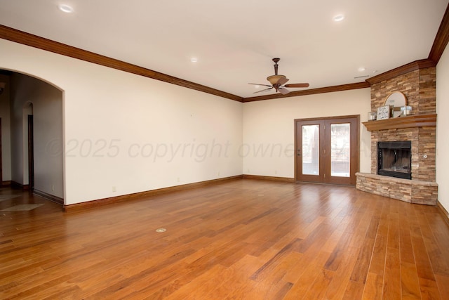 4602 Cape Verde Ct, Amarillo, TX 79119 - unfurnished living room featuring a ceiling fan, wood finished floors, arched walkways, crown molding, and a fireplace