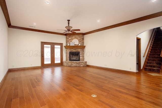 4602 Cape Verde Ct, Amarillo, TX 79119 - unfurnished living room with a ceiling fan, crown molding, a large fireplace, wood finished floors, and stairs