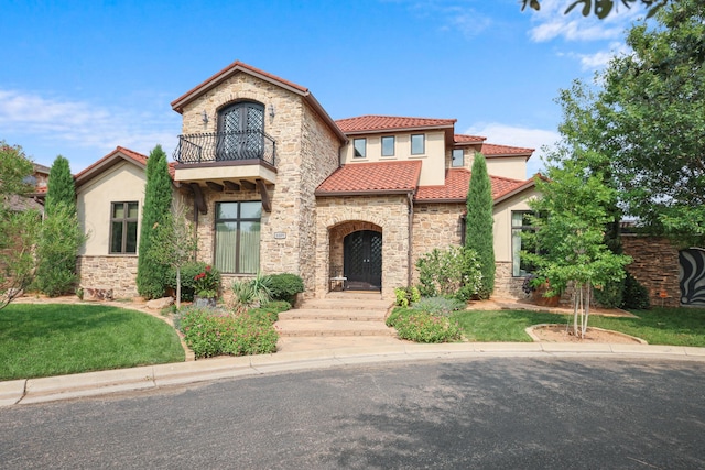 mediterranean / spanish-style home with a balcony and a front yard