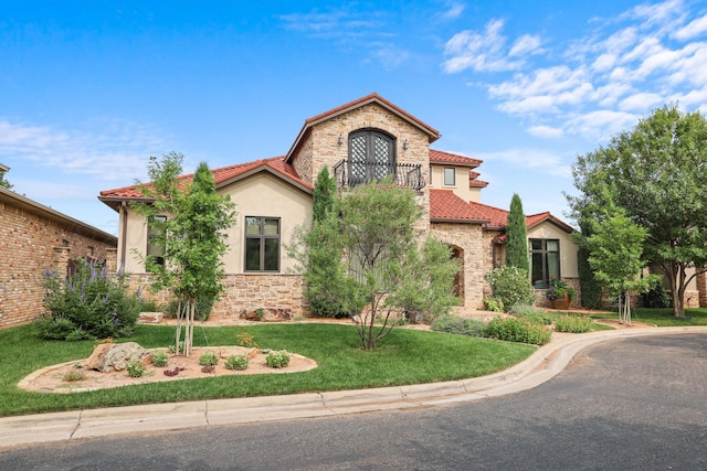 mediterranean / spanish home with a front lawn