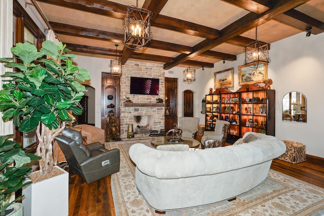 living room featuring coffered ceiling, hardwood / wood-style floors, beam ceiling, and a large fireplace