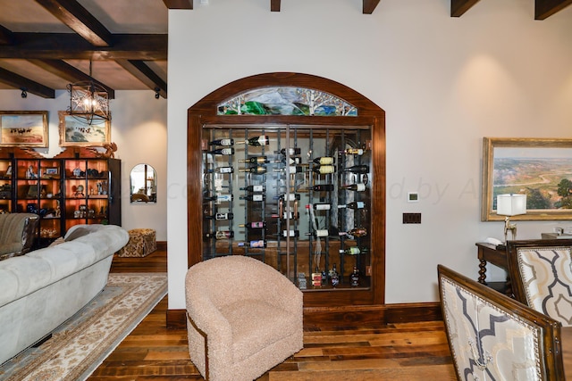 wine room featuring beamed ceiling, dark hardwood / wood-style floors, and an inviting chandelier