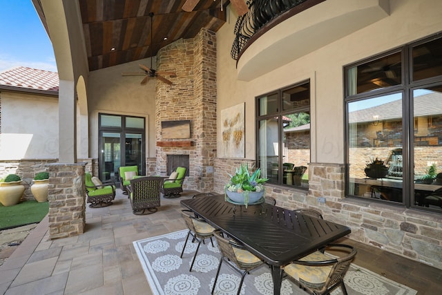 view of patio featuring ceiling fan and a fireplace