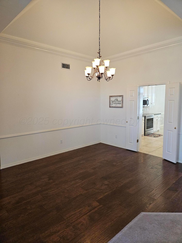 7205 Columbia Ln, Amarillo, TX 79109 - empty room featuring a chandelier, wood finished floors, ornamental molding, and high vaulted ceiling