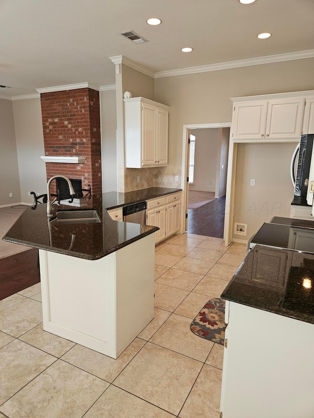 7205 Columbia Ln, Amarillo, TX 79109 - kitchen with stainless steel appliances, a peninsula, light tile patterned floors, ornamental molding, and a brick fireplace