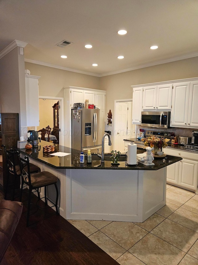 7205 Columbia Ln, Amarillo, TX 79109 - kitchen with stainless steel appliances, ornamental molding, white cabinets, recessed lighting, and light tile patterned floors