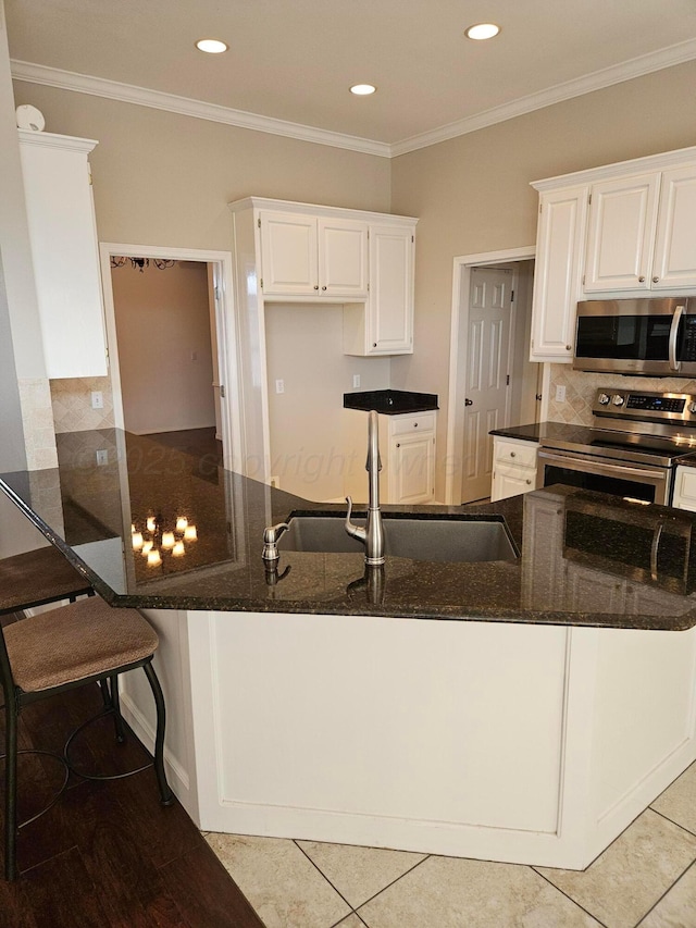 7205 Columbia Ln, Amarillo, TX 79109 - kitchen with appliances with stainless steel finishes, dark stone countertops, white cabinets, decorative backsplash, and crown molding