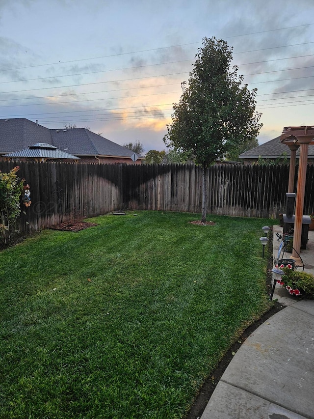 7205 Columbia Ln, Amarillo, TX 79109 - yard at dusk with a fenced backyard