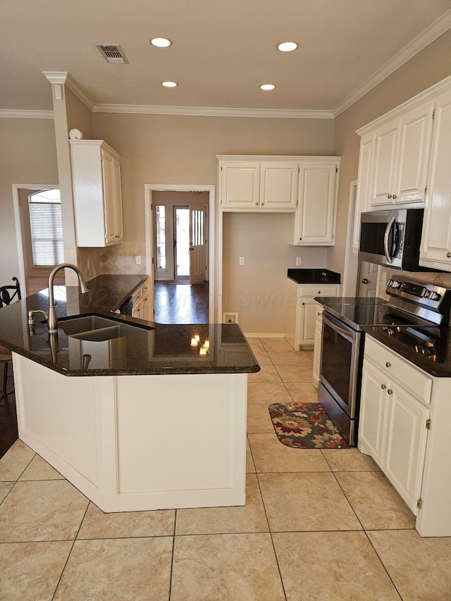 7205 Columbia Ln, Amarillo, TX 79109 - kitchen featuring appliances with stainless steel finishes, a peninsula, dark stone countertops, ornamental molding, and white cabinets
