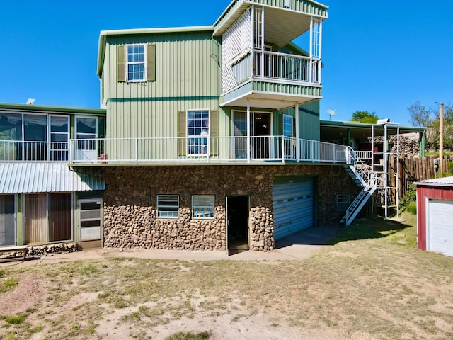 back of property featuring a garage and a balcony