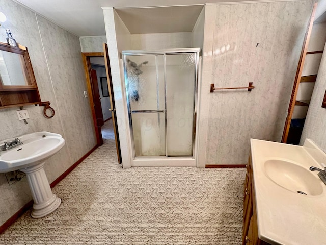 bathroom featuring a shower with door and sink