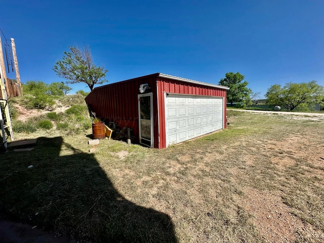 view of outbuilding with a garage and a lawn