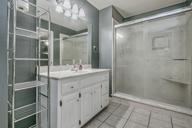 bathroom with tile patterned flooring, a stall shower, and vanity