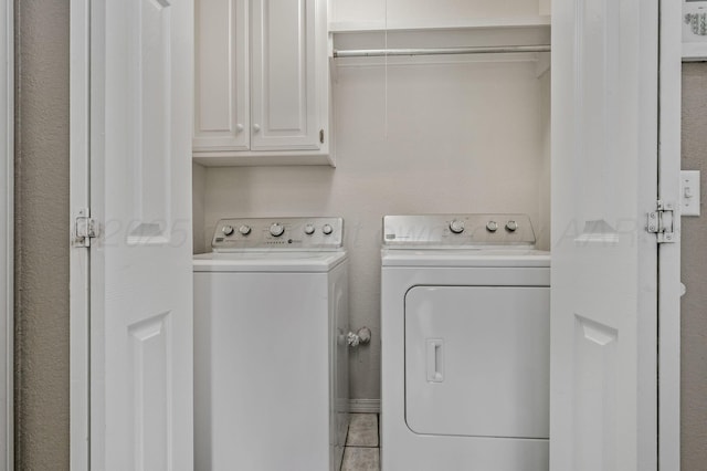 laundry room featuring cabinet space, washing machine and dryer, and tile patterned floors