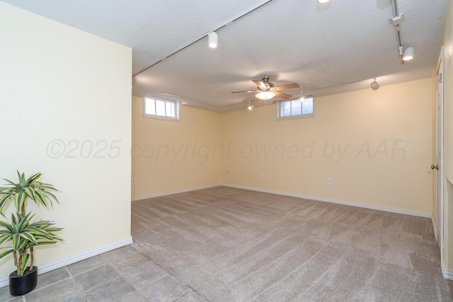 unfurnished room featuring ceiling fan, carpet flooring, a textured ceiling, and rail lighting