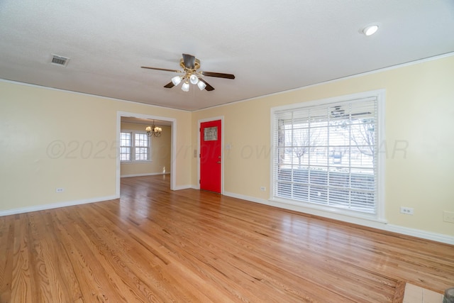 spare room featuring ceiling fan with notable chandelier, a textured ceiling, and light wood-type flooring