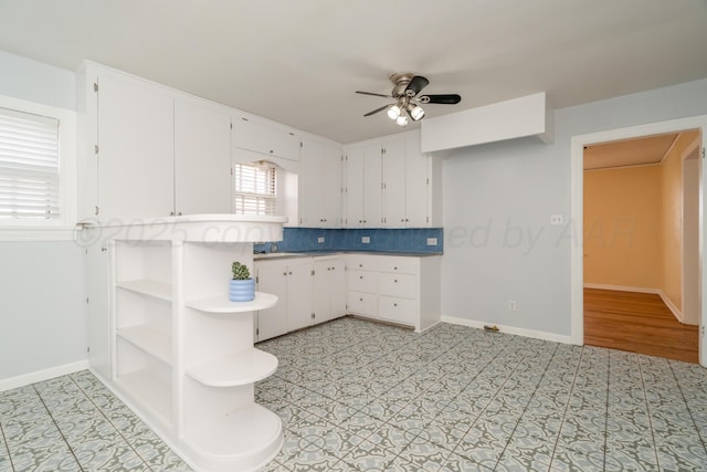 kitchen with tasteful backsplash, white cabinets, and ceiling fan