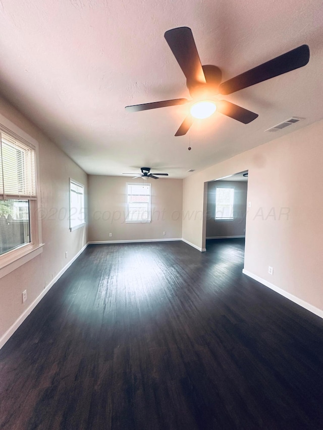 704 3rd Pl, Dumas, TX 79029 - spare room with dark wood-style floors and a ceiling fan