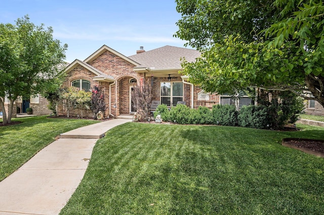7402 Southbend Dr, Amarillo, TX 79119 - view of front of home with brick siding, a front yard, a chimney, a shingled roof, and a ceiling fan