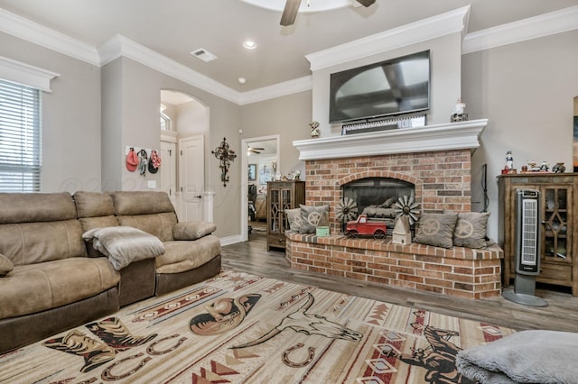 7402 Southbend Dr, Amarillo, TX 79119 - living room featuring ceiling fan, arched walkways, wood finished floors, a fireplace, and ornamental molding