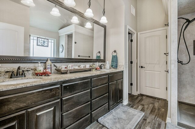 7402 Southbend Dr, Amarillo, TX 79119 - full bathroom featuring double vanity, wood finished floors, and a tile shower