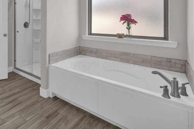 9110 Lexford Dr, Amarillo, TX 79119 - bathroom featuring a bath, a stall shower, and wood finished floors