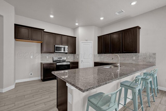 9110 Lexford Dr, Amarillo, TX 79119 - kitchen with appliances with stainless steel finishes, dark stone countertops, light wood-style floors, and recessed lighting