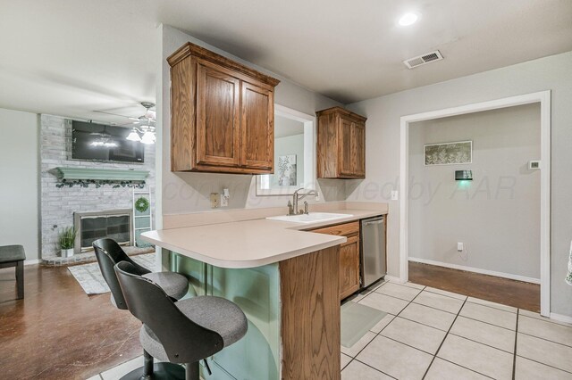 2002 SW 61st Ave, Amarillo, TX 79118 - kitchen with a sink, stainless steel dishwasher, a kitchen bar, brown cabinetry, and light countertops