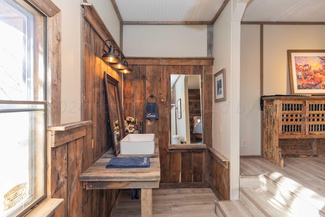 interior space with light wood-type flooring and wooden walls