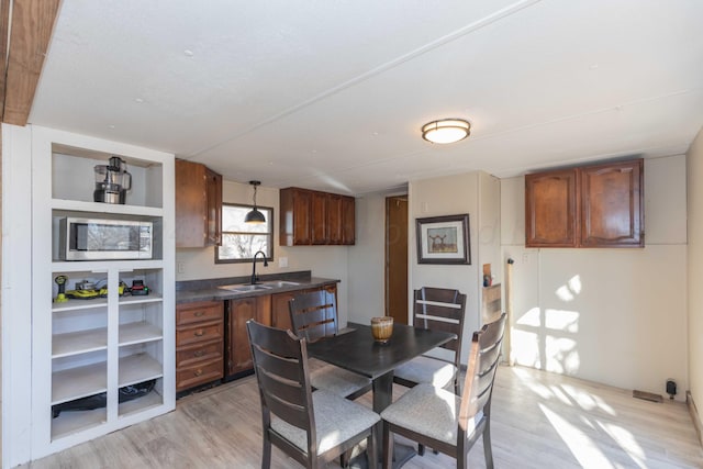 dining area with light hardwood / wood-style floors and sink