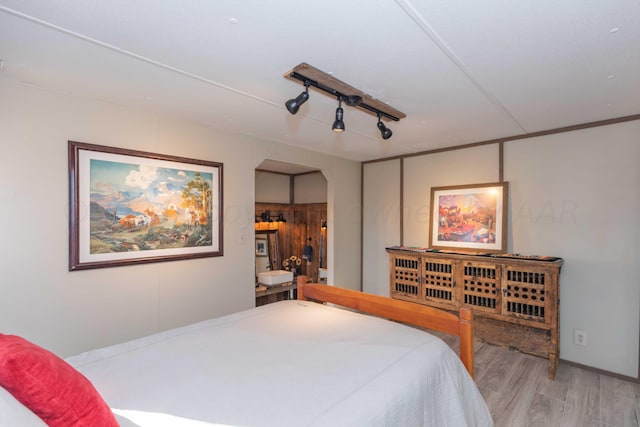 bedroom featuring light hardwood / wood-style floors and ensuite bath