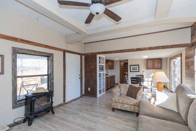 living room featuring beamed ceiling, ceiling fan, a healthy amount of sunlight, and light hardwood / wood-style flooring