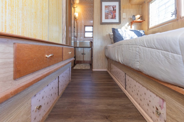 bedroom with multiple windows and dark hardwood / wood-style floors