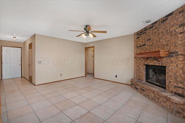 unfurnished living room with a fireplace, light tile patterned flooring, and a textured ceiling