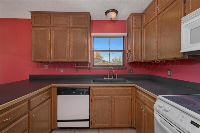 kitchen with sink, white appliances, and a textured ceiling