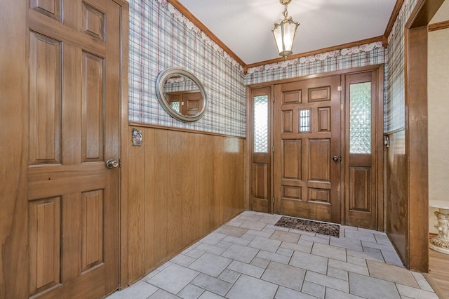 613 Bennett Dr, Dumas, TX 79029 - foyer featuring wallpapered walls, ornamental molding, wainscoting, and wood walls
