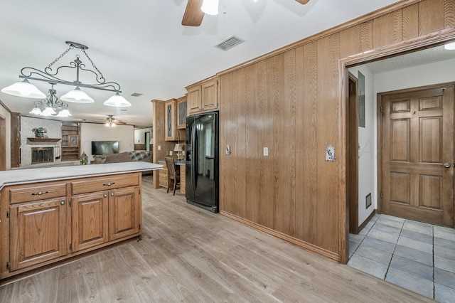 613 Bennett Dr, Dumas, TX 79029 - kitchen featuring a ceiling fan, black refrigerator with ice dispenser, brown cabinets, and light countertops