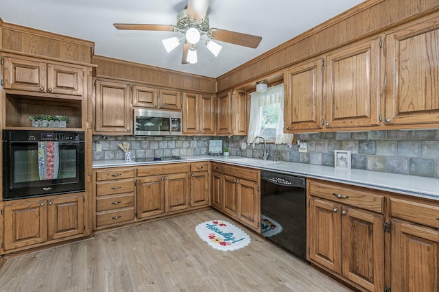 613 Bennett Dr, Dumas, TX 79029 - kitchen featuring black appliances, a sink, brown cabinets, decorative backsplash, and light countertops