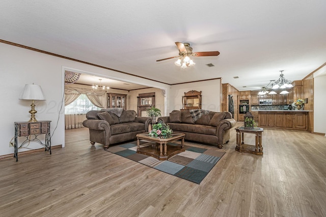 613 Bennett Dr, Dumas, TX 79029 - living room featuring a chandelier, light wood-style floors, ceiling fan, ornamental molding, and baseboards