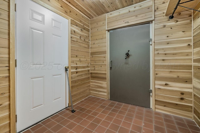 613 Bennett Dr, Dumas, TX 79029 - entryway with wooden walls, wood ceiling, and dark tile patterned floors