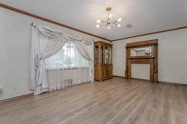 613 Bennett Dr, Dumas, TX 79029 - unfurnished room featuring a chandelier, light wood-type flooring, ornamental molding, a textured ceiling, and baseboards