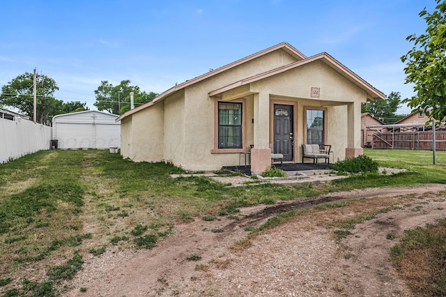 126 S Nelson St, Pampa, TX 79065 - view of front of house with stucco siding, a detached garage, and a porch