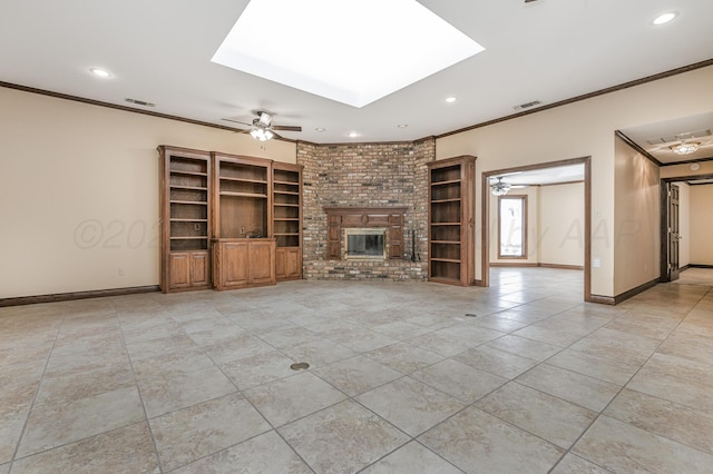 unfurnished living room with ornamental molding, a skylight, visible vents, and a brick fireplace