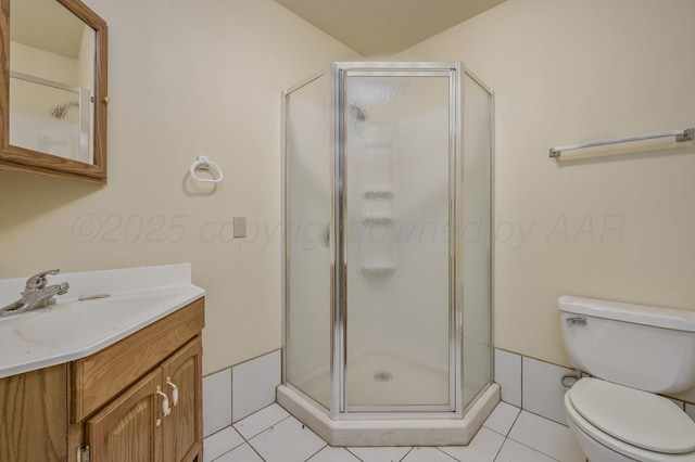 bathroom featuring vanity, tile patterned flooring, a shower stall, and toilet