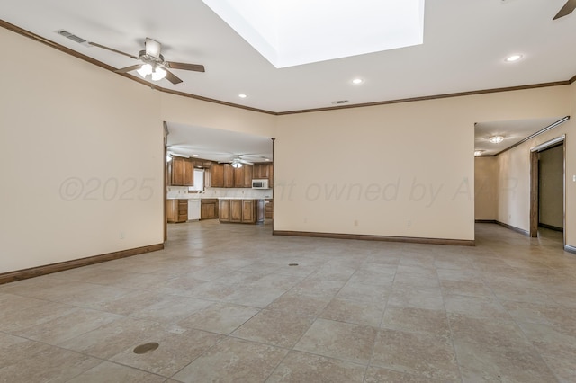 unfurnished living room with a skylight, visible vents, crown molding, and ceiling fan