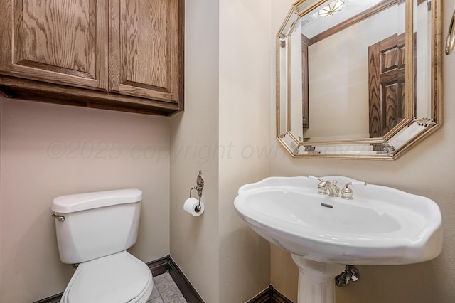 bathroom with toilet and baseboards