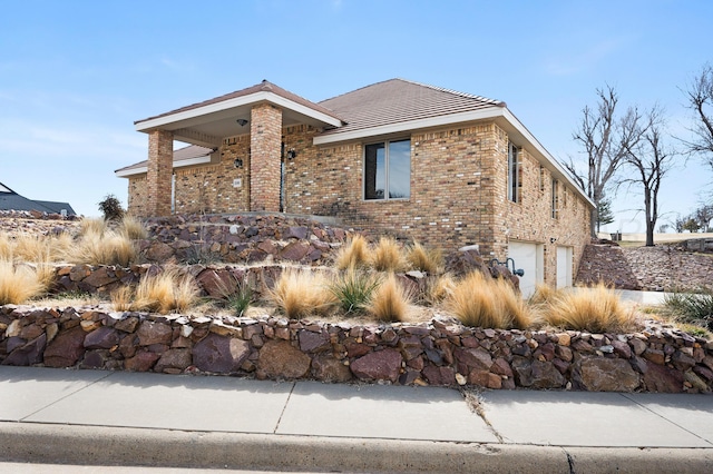 view of front of property with brick siding, driveway, and an attached garage