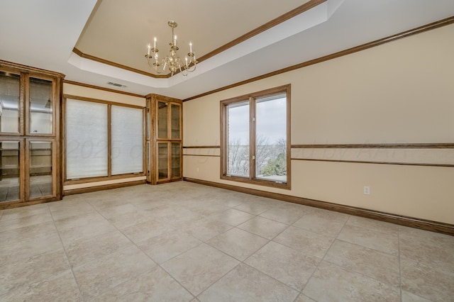 spare room featuring visible vents, baseboards, ornamental molding, a raised ceiling, and an inviting chandelier