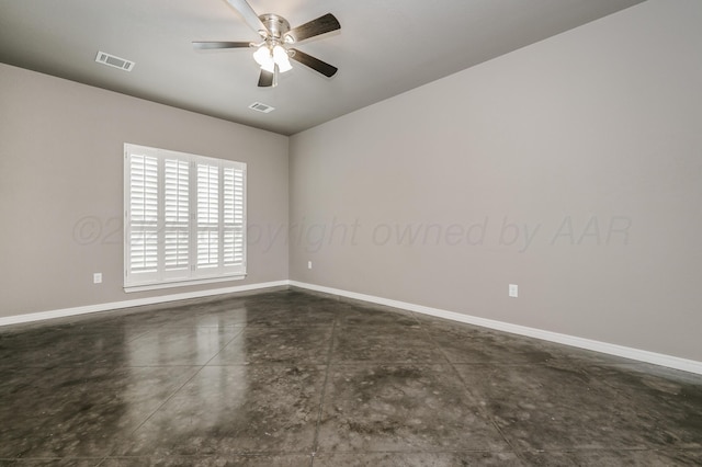 unfurnished room featuring concrete flooring, visible vents, and baseboards