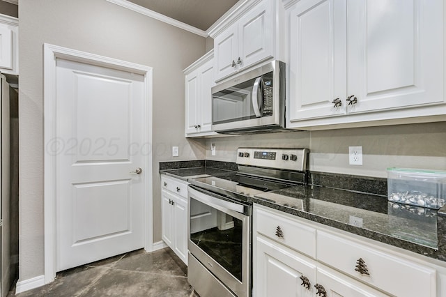 kitchen with white cabinetry, baseboards, appliances with stainless steel finishes, dark stone countertops, and crown molding